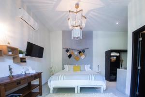 新巴利亚塔Villas Parota Inn的一间卧室配有一张床和一个吊灯