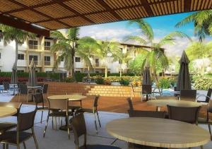 塞古罗港Apartamento Ondas Resort的一间设有桌椅的餐厅,种植了棕榈树
