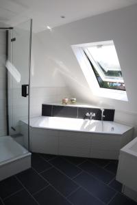加格瑙Ferienwohnung Habitat的带淋浴和浴缸的浴室以及窗户