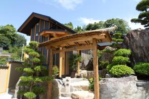 高千穗町神泉旅馆的花园内带木制凉棚的房屋