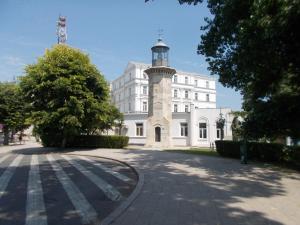 康斯坦察Peninsula-Cazino,Dalvi的街道上一座白色的建筑,有钟楼