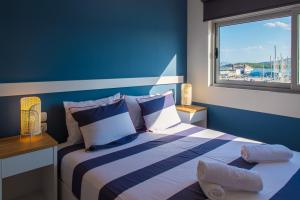 沃洛斯Central Marine Flat的蓝色的客房设有一张带窗户的床