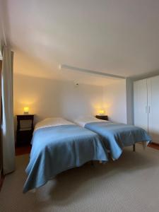 马尔旺Casa do Sétimo Passo的一间卧室配有两张带蓝色棉被的床