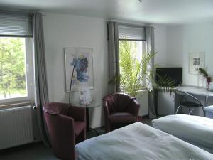 霍夫氛围酒店的酒店客房带两张床和一张桌子以及椅子。