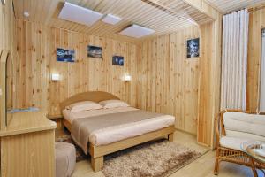 阿尔特巴什Tourist complex Gornoe Ozero的卧室配有一张床铺,位于带木墙的房间内
