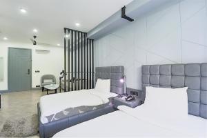 古尔冈BedChambers Serviced Apartments - Cyber City的一间卧室配有两张床、一张桌子和一把椅子