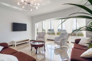 塞尔瓦Can Pasos的客厅配有沙发、椅子和电视
