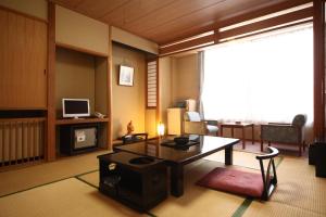 十和田十和田庄酒店的客厅配有咖啡桌和电视