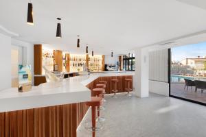帕尔马海滩Hotel Principe Wellness&Spa的厨房设有带棕色凳子的酒吧