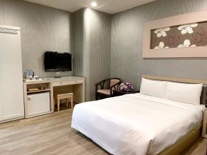 基隆北都大饭店的一间卧室配有一张床和一张书桌及电视