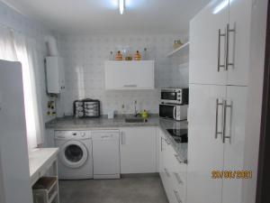 桑卢卡尔-德巴拉梅达CALLE YERBABUENA 5的白色的厨房配有洗衣机和洗衣机