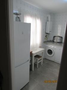 桑卢卡尔-德巴拉梅达CALLE YERBABUENA 5的厨房配有白色冰箱和洗衣机。