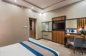 利雅德Myrtle Hotel - Al Sahafa的配有一张床和一张书桌的酒店客房
