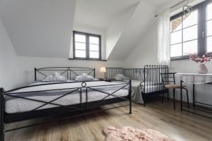 韦特利纳Wetlinowo的一间卧室设有一张黑色的床和两个窗户。