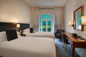 伦敦斯隆广场酒店的酒店客房配有两张床和一张书桌