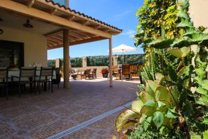 圣米格尔德阿沃纳Villa Golf y Mar的庭院配有桌椅和遮阳伞。