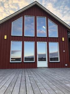 莱克内斯Amazing fisherman cabin in the heart of Lofoten的红色的建筑,设有窗户和木甲板