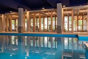 伦策海德Sunstar Hotel Lenzerheide的大楼内带椅子的游泳池