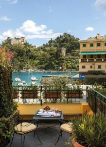 波托菲诺Splendido Mare, A Belmond Hotel, Portofino的阳台配有桌椅,享有海港的景致。