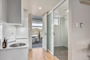纳拉库特Aloha Central Luxury Accommodation的白色的浴室设有水槽和淋浴。