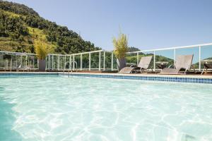 安格拉杜斯雷斯安格拉海滩酒店的一个带椅子的游泳池和一个山