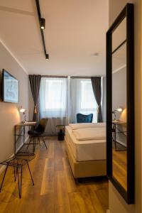 勒沃库森Nikii City Hotel的一间卧室配有一张床和镜子