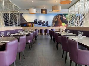 吉斯朗恩Hotel-Restaurant Horizon Ath-Lessines的一间用餐室,配有紫色的椅子和桌子