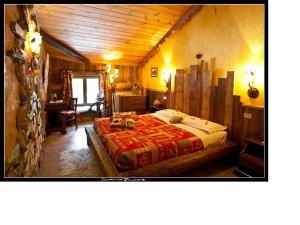喇沙Baita La Jolie Bergere的一间卧室设有一张带木制天花板的大床