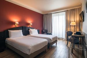 斯特拉斯堡乐格兰德酒店的酒店客房设有两张床和红色的墙壁。