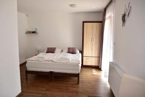 Mikulov v Krušných Horách克布旅馆的卧室配有白色的床,铺有木地板