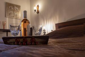 埃普塔罗弗斯Guesthouse Alexandra的床上的一瓶葡萄酒和两杯酒杯