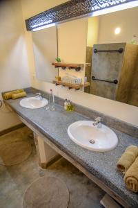 育空河Arusha Villa Karamu Coffee Estate的一间带两个盥洗盆和大镜子的浴室