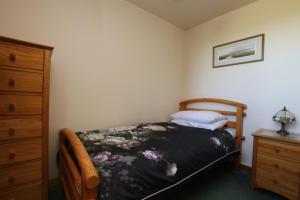 LybsterTaigh An Clachair的一间小卧室,配有一张床和一个梳妆台
