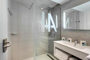 卢尔德阿尔巴酒店的白色的浴室设有水槽和淋浴。