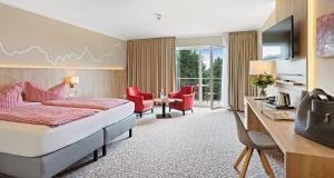 奥伯霍夫Hotel & Pension Traumblick的酒店客房,配有一张床、一张桌子和椅子