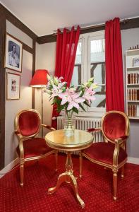 图尔LOGIS Hôtel Du Théâtre的客厅配有两把椅子和一张鲜花桌