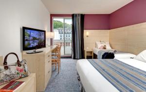 卢尔德阿尔巴酒店的酒店客房设有两张床和一台平面电视。