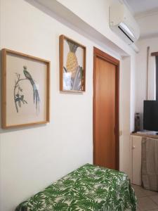 丽都迪奥斯蒂亚Appartamento Jungle Beach的一间房间,配有一张床,墙上有两张照片