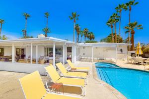 棕榈泉Shooting Star Permit# 3210的一个带椅子的游泳池以及一座棕榈树房子