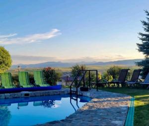图尔达Wineyards Salin的一个带椅子的游泳池,享有山景