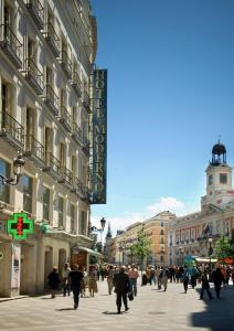 马德里Hotel Moderno Puerta del Sol的一群人沿着城市街道走着