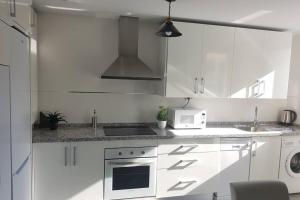 格拉纳达CABRIA APARTMENT的白色的厨房配有炉灶和微波炉。