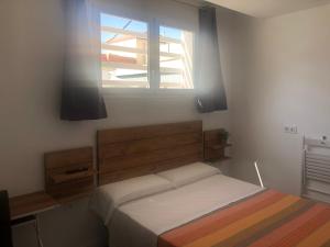 桑卢卡尔-德巴拉梅达La Estación的一间卧室设有一张床和一个窗口