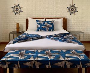 圣多美São Pedro Guesthouse的一张带蓝色和白色床单及枕头的床