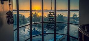 索瓦马The Precious Guesthouse的享有游泳池和日落美景的窗户