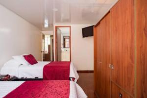 波哥大Touristic House的酒店客房设有两张床和橱柜。