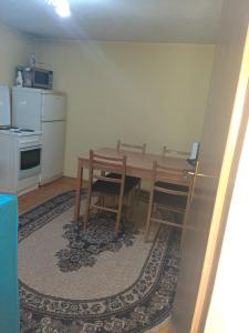 特拉夫尼克Stari Grad Migy Travnik Apartman的一间带木桌的厨房和一间带炉灶的厨房