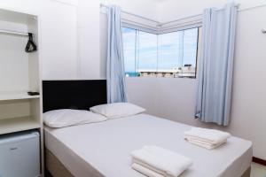 纳塔尔Economy Hotel的卧室配有白色的床和窗户