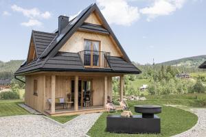 维托韦Domki Fox House的院子里有黑色屋顶的小房子