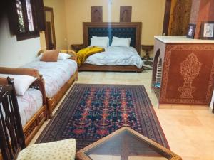 马拉喀什Flashback House的客厅配有两张床和地毯。